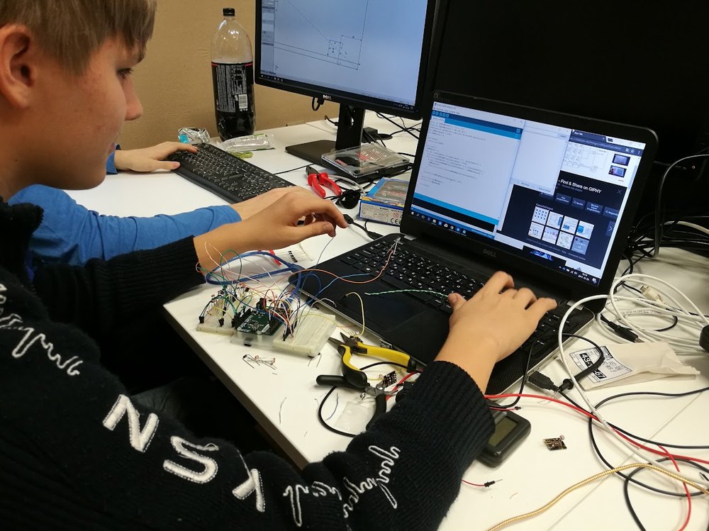 Diák breadboardon áramkört programoz laptopon